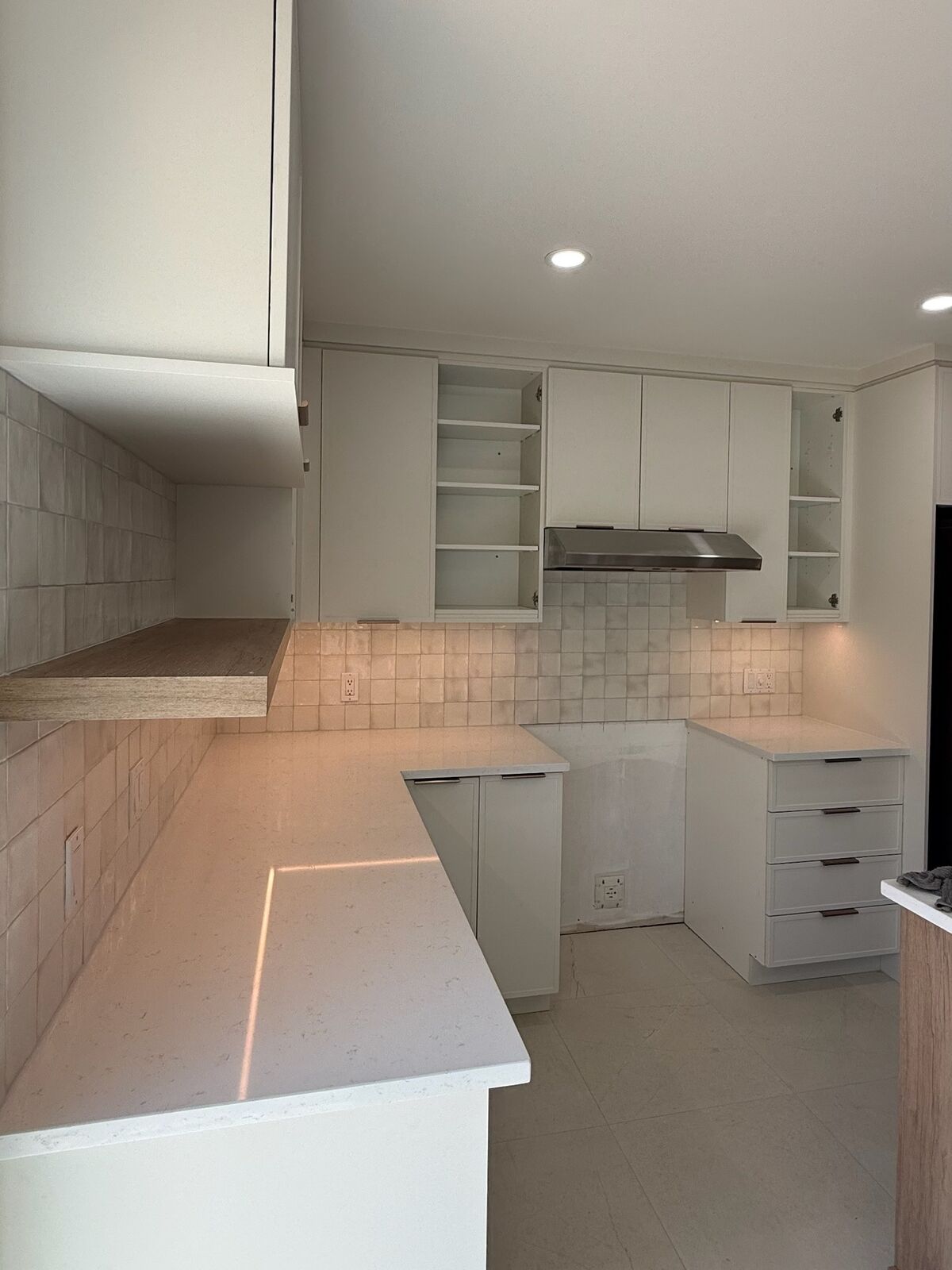 Cuisine blanche avec dosseret en carreaux zellige et comptoir de quartz