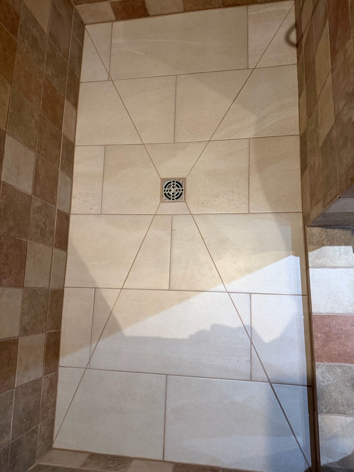 Fond de douche terminé, carreaux coupés en enveloppe vers un drain carré